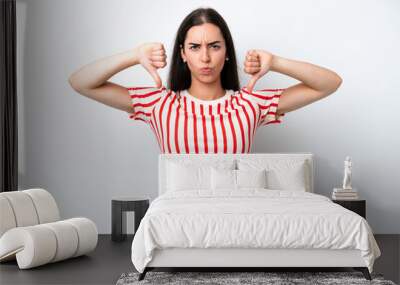 Young caucasian woman isolated on white background showing thumb down with two hands Wall mural