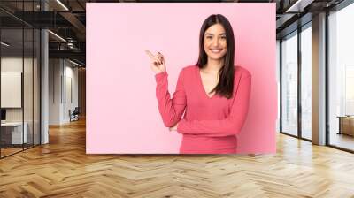 Young caucasian woman over isolated background happy and pointing up Wall mural