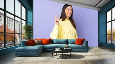 Young caucasian woman over isolated background smiling and showing victory sign Wall mural