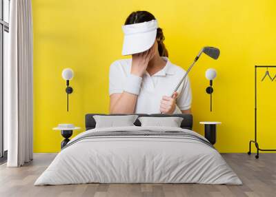 young caucasian woman playing golf isolated on yellow background with tired and sick expression Wall mural