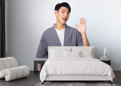 Young Chinese man isolated on white background saluting with hand with happy expression Wall mural