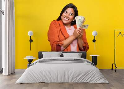 Young Colombian girl over yellow wall taking a lot of money Wall mural