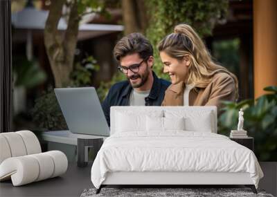 Young couple at outdoors working with a laptop Wall mural