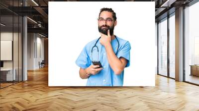 Young doctor man over isolated chroma key background thinking and sending a message Wall mural