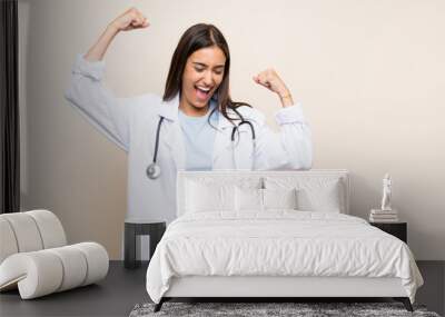 Young doctor woman over isolated background celebrating a victory Wall mural