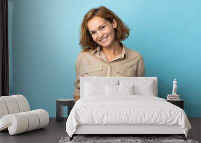 Young Georgian woman isolated on blue background laughing Wall mural