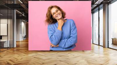 Young Georgian woman isolated on pink background with glasses and smiling Wall mural