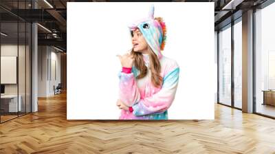 Young girl with unicorn pajamas over isolated chroma key background pointing to the side to present a product Wall mural