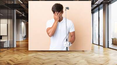 Young golfer player man isolated on ocher background with tired and sick expression Wall mural