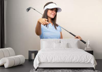 young golfer woman over isolated background points finger at you with a confident expression Wall mural