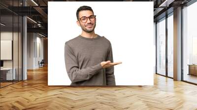 Young handsome caucasian man over isolated background presenting an idea while looking smiling towards Wall mural