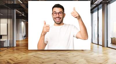 Young handsome caucasian man over isolated chroma key background giving a thumbs up gesture Wall mural