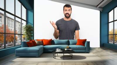 Young handsome man over isolated white background making doubts gesture Wall mural