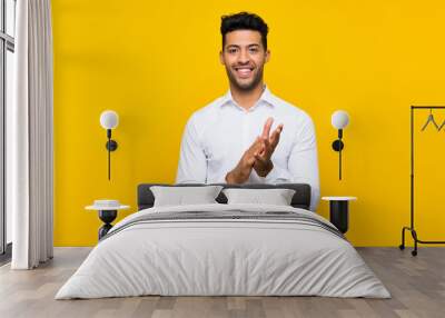 Young handsome man over isolated yellow background applauding Wall mural