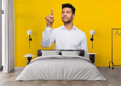 Young handsome man over isolated yellow background touching on transparent screen Wall mural