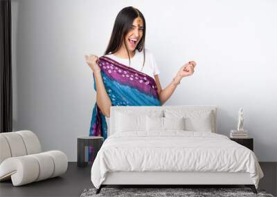 Young Indian woman isolated on white background making guitar gesture Wall mural