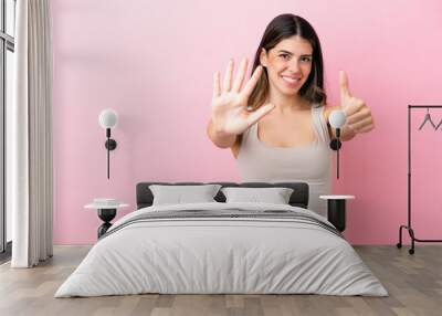 Young Italian woman isolated on pink background counting six with fingers Wall mural