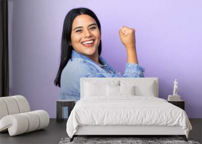 Young latin woman woman over isolated background doing strong gesture Wall mural