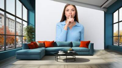 Young Lithuanian woman isolated on white background showing a sign of silence gesture putting finger in mouth Wall mural