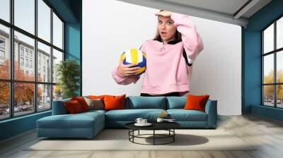 Young Lithuanian woman playing volleyball isolated on white background doing surprise gesture while looking to the side Wall mural