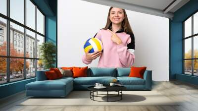 Young Lithuanian woman playing volleyball isolated on white background pointing to the side to present a product Wall mural