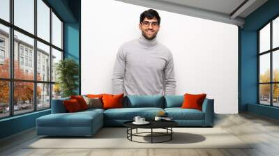 young man over isolated white wall with glasses and happy Wall mural