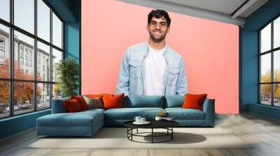 Young man over pink wall with glasses and happy Wall mural