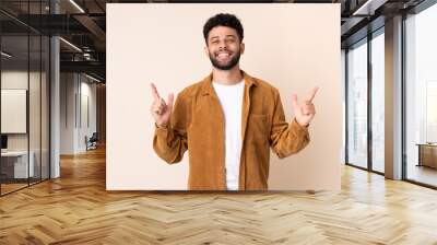 Young Moroccan man isolated on beige background pointing up a great idea Wall mural