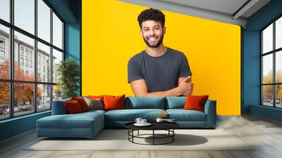 Young Moroccan man isolated on yellow background laughing Wall mural