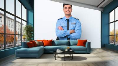 Young police caucasian man isolated on white background keeping the arms crossed in frontal position Wall mural