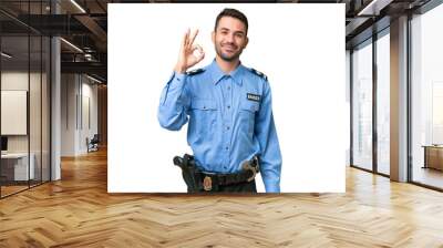 Young police caucasian man over isolated background showing ok sign with fingers Wall mural