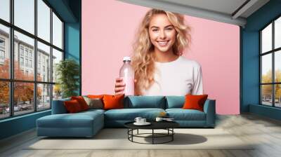 Young pretty blonde girl over isolated colorful background holding a bottle of water Wall mural