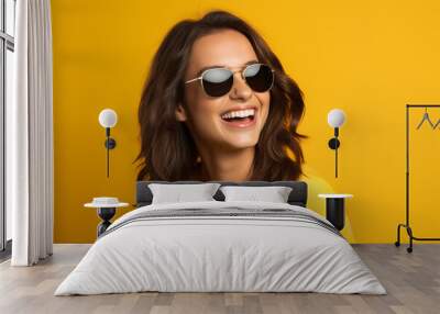 Young pretty brunette girl over isolated colorful background with sunglasses Wall mural