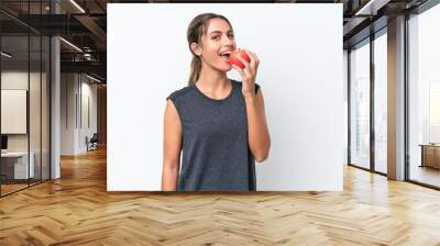 Young pretty Uruguayan woman isolated on white background eating an apple Wall mural