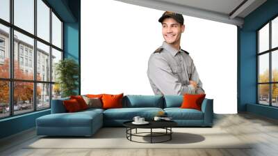 Young security man over isolated background with arms crossed and happy Wall mural