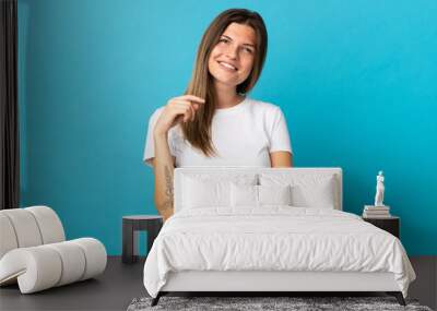 Young slovak woman isolated on blue background laughing Wall mural