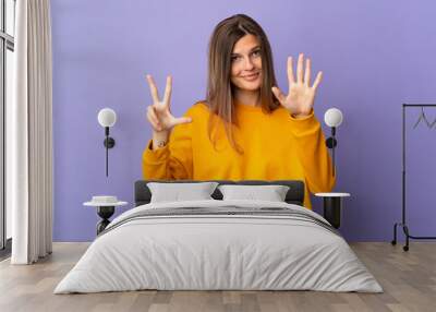 Young Slovak woman isolated on purple background counting eight with fingers Wall mural