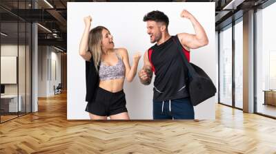 Young sport couple isolated on white background celebrating a victory in winner position Wall mural