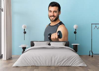 Young sport man with beard making weightlifting smiling a lot Wall mural