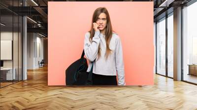 Young sport woman over isolated pink background nervous and scared Wall mural