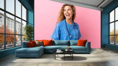 Young surgeon doctor woman isolated on pink background looking side Wall mural