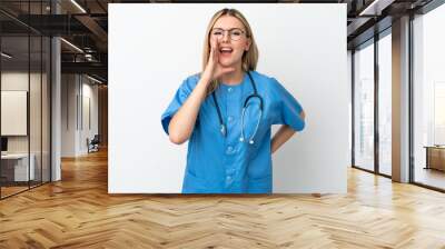 Young surgeon doctor woman isolated on white background shouting with mouth wide open Wall mural