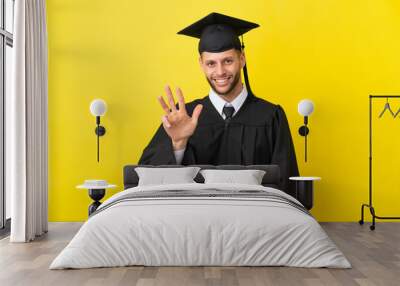 Young university graduate caucasian man isolated on yellow background happy and counting four with fingers Wall mural