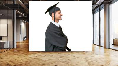 Young university graduate caucasian man over isolated background in lateral position Wall mural