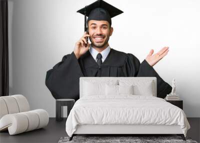 Young university graduate man over isolated background keeping a conversation with the mobile phone with someone Wall mural