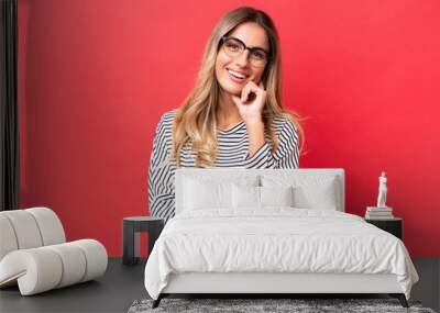 Young Uruguayan woman isolated on red background happy and smiling Wall mural