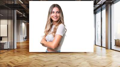 Young Uruguayan woman over isolated background with arms crossed and happy Wall mural