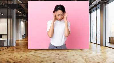 Young Vietnamese woman isolated on pink background with headache Wall mural