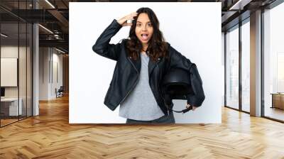 Young woman holding a motorcycle helmet over isolated white background with surprise expression Wall mural