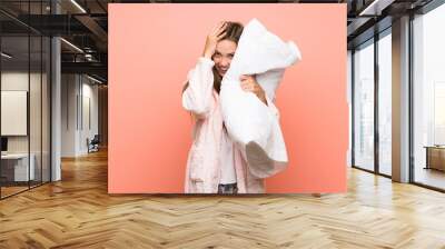 Young woman in dressing gown over pink wall with surprise facial expression Wall mural